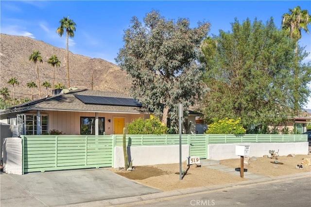 view of front of house with a mountain view and solar panels