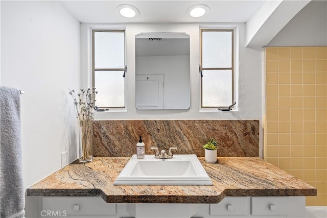 bathroom featuring vanity and tasteful backsplash