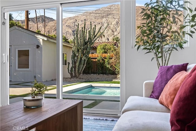 doorway to outside featuring a mountain view, a patio area, and a fenced in pool