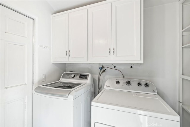 washroom featuring washer and clothes dryer and cabinets