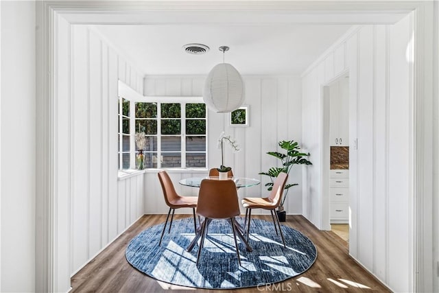 dining room with wood-type flooring and crown molding