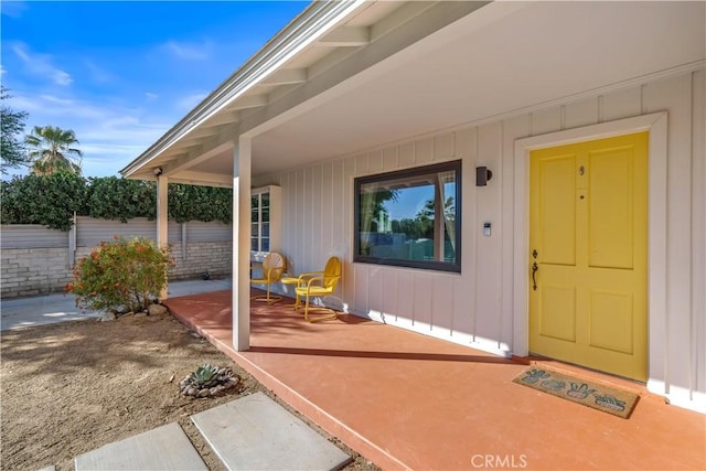 doorway to property with covered porch and a patio