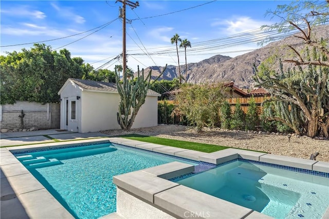 view of pool featuring an outdoor structure, a mountain view, and an in ground hot tub