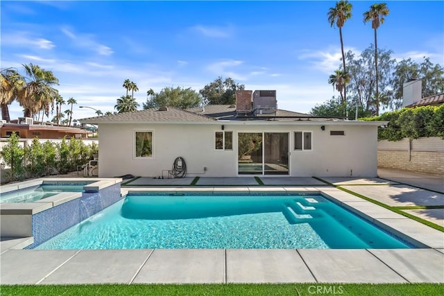 back of house with a patio area, cooling unit, and a pool with hot tub