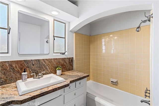 bathroom with vanity, a wealth of natural light, and tiled shower / bath combo