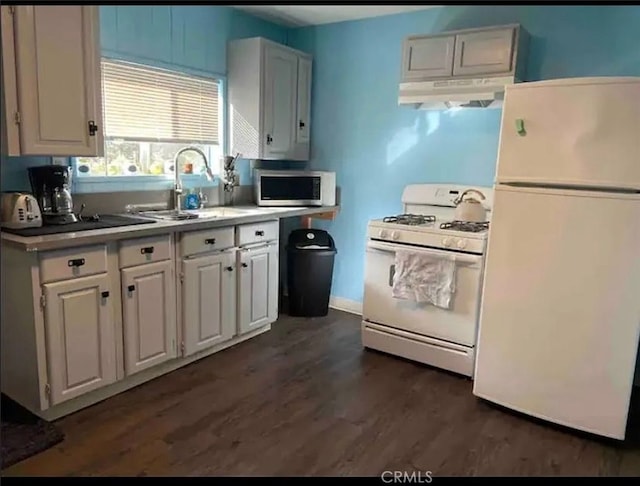 kitchen with white appliances, exhaust hood, white cabinets, sink, and dark hardwood / wood-style flooring