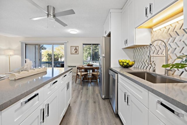 kitchen featuring light hardwood / wood-style floors, white cabinetry, and sink