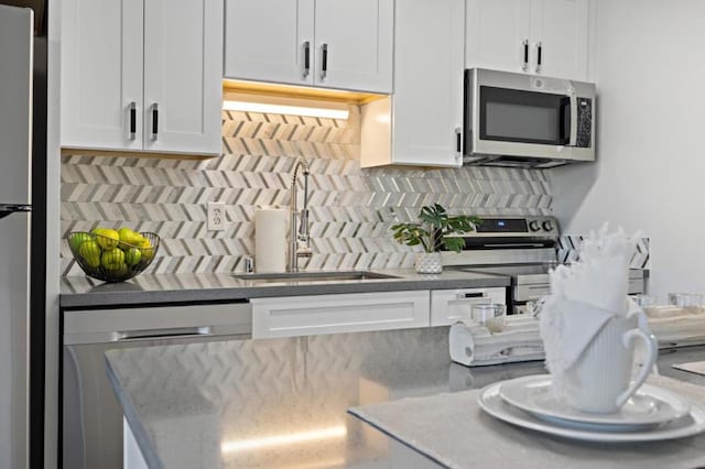 kitchen featuring white cabinets, sink, stainless steel appliances, and tasteful backsplash