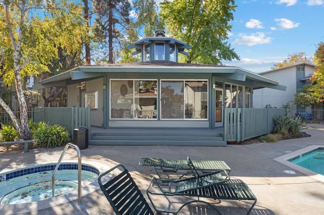 back of property with a patio area and a swimming pool with hot tub