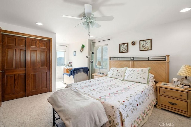 bedroom with ceiling fan, a closet, and light colored carpet