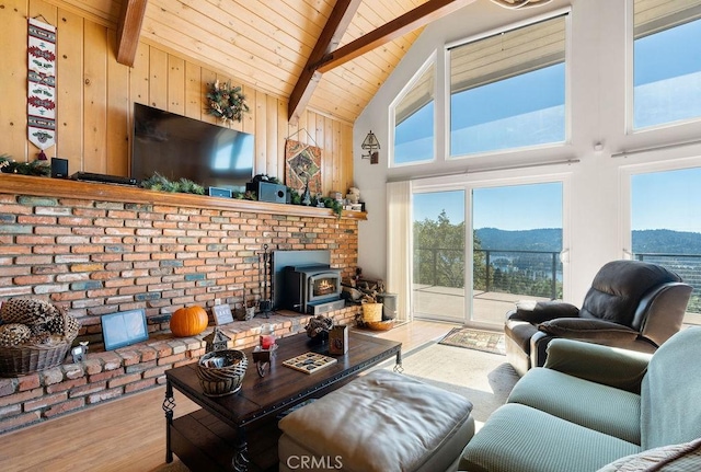 living room with beam ceiling, a wood stove, high vaulted ceiling, wood-type flooring, and wood ceiling