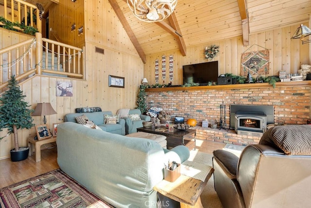 living room with hardwood / wood-style flooring, wood walls, and beam ceiling