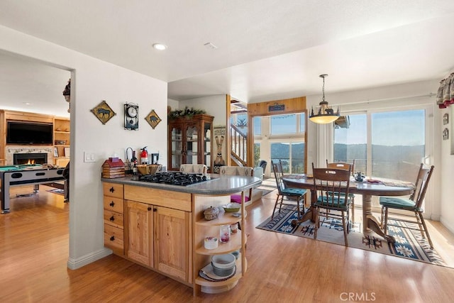 kitchen with hanging light fixtures, light wood-type flooring, and stainless steel gas cooktop