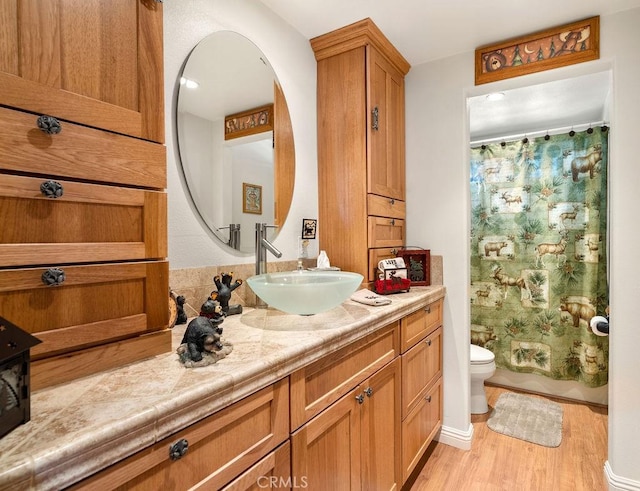 full bathroom with hardwood / wood-style floors, vanity, toilet, and shower / bath combination with curtain