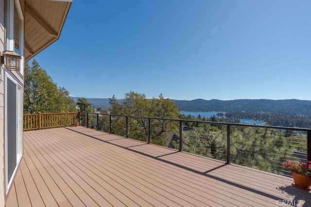 wooden deck featuring a water and mountain view