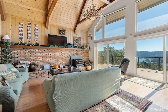 living room with a wood stove, wooden ceiling, an inviting chandelier, light wood-type flooring, and beamed ceiling