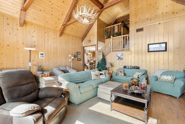 living room with high vaulted ceiling, beam ceiling, wood ceiling, and wooden walls