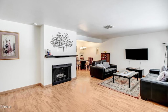 living room with hardwood / wood-style floors and an inviting chandelier