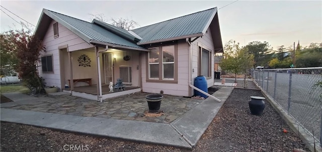 view of front of home featuring fence and metal roof