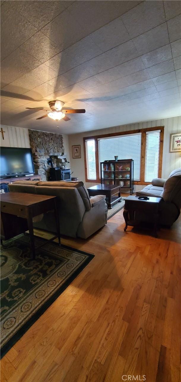 living area with ceiling fan and wood finished floors