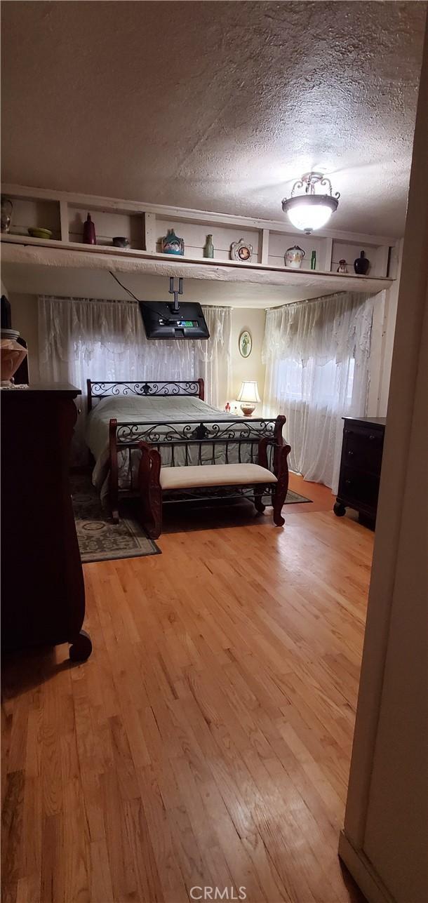 bedroom with wood-type flooring and a textured ceiling