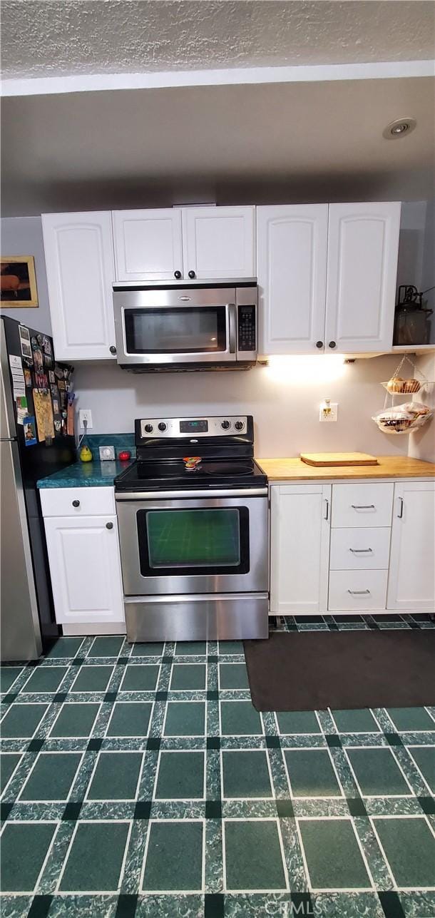 kitchen featuring stainless steel appliances and white cabinetry