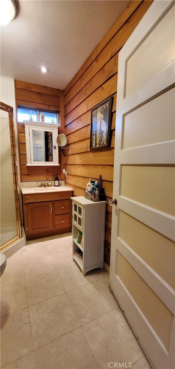 bathroom featuring vanity, wooden walls, and a shower with shower door