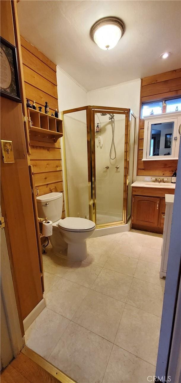 bathroom featuring tile patterned flooring, vanity, toilet, and walk in shower