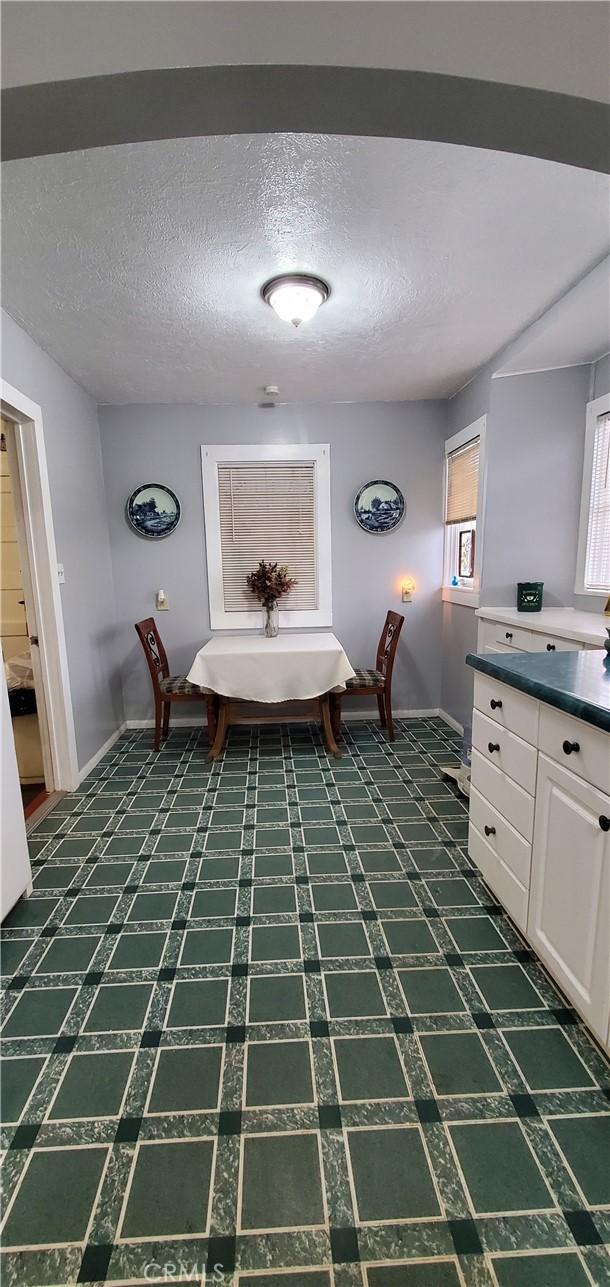 unfurnished dining area with a textured ceiling