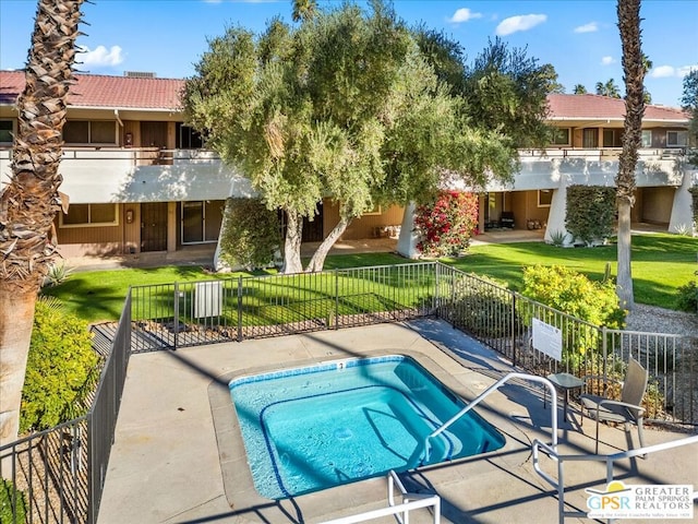 view of pool featuring a patio area, a yard, and a hot tub