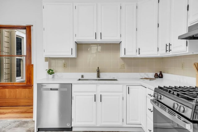 kitchen with decorative backsplash, sink, white cabinetry, and appliances with stainless steel finishes