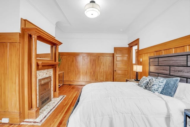 bedroom featuring light hardwood / wood-style floors and a tile fireplace