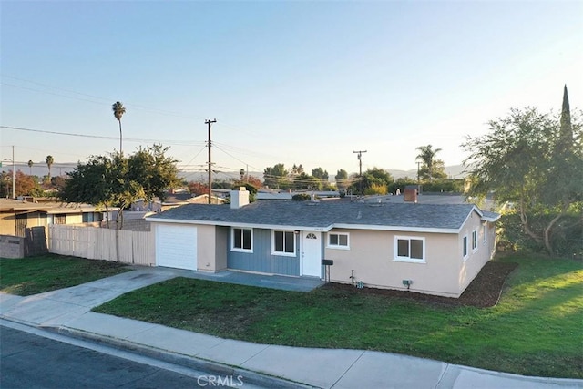 single story home featuring a garage and a front lawn