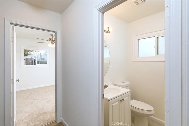 bathroom featuring toilet, vanity, ceiling fan, and a wealth of natural light