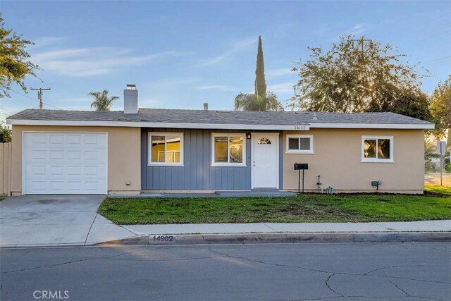 ranch-style home featuring a garage and a front lawn