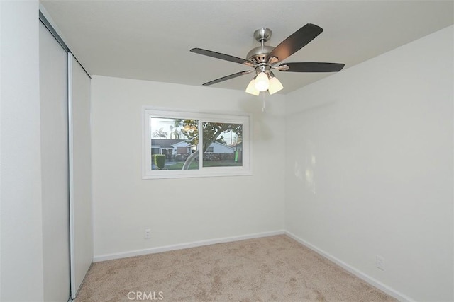 unfurnished bedroom with ceiling fan, light carpet, and a closet