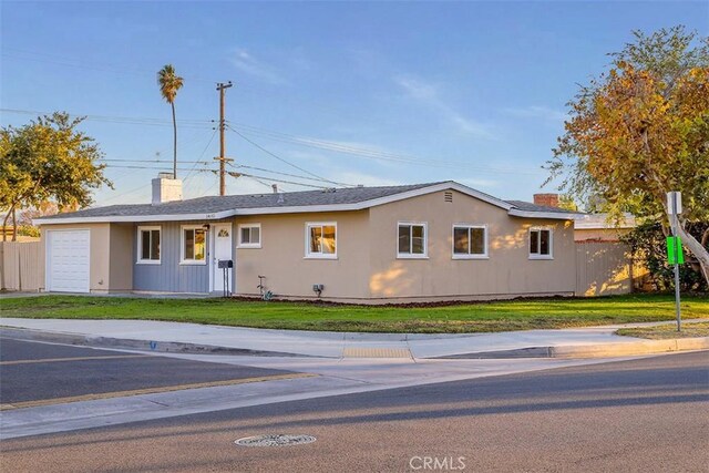 single story home featuring a garage and a front yard