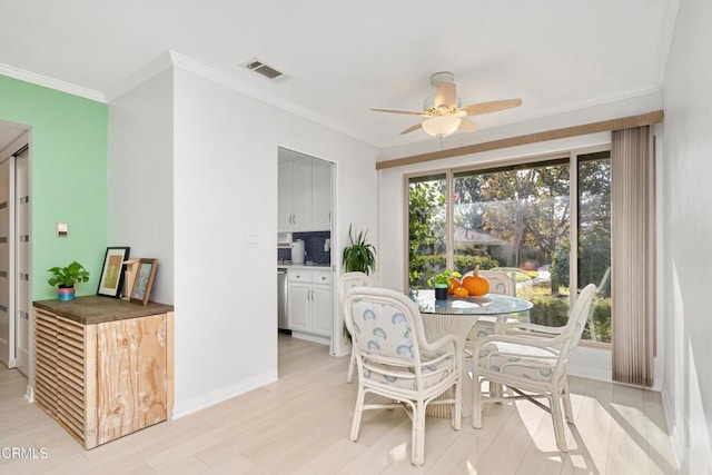 dining room with ceiling fan, light wood-type flooring, and crown molding