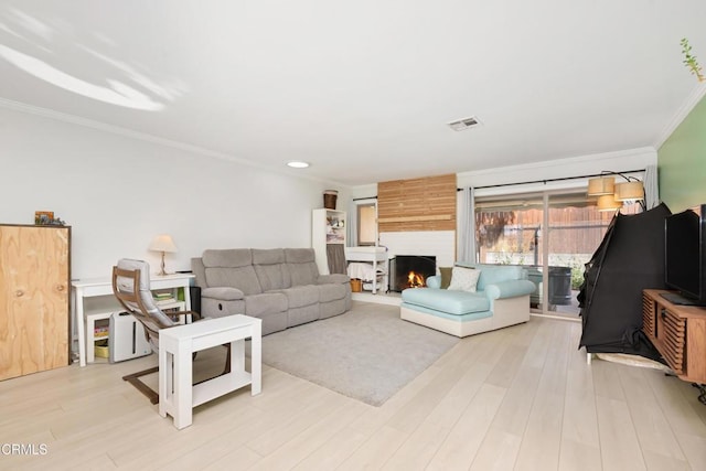 living room featuring crown molding and light hardwood / wood-style flooring