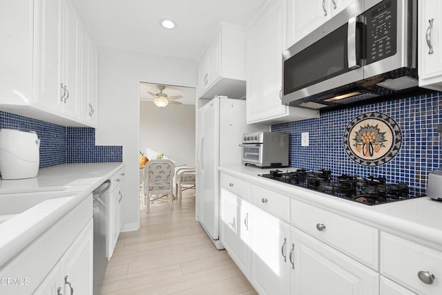 kitchen featuring backsplash, white cabinetry, and stainless steel appliances