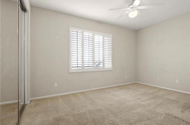 carpeted empty room featuring ceiling fan