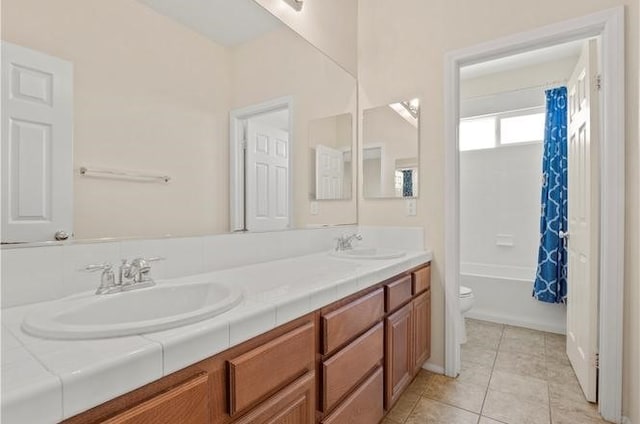 full bathroom featuring tile patterned floors, shower / bath combo with shower curtain, vanity, and toilet