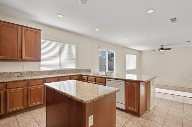 kitchen with ceiling fan, dishwasher, sink, kitchen peninsula, and a kitchen island