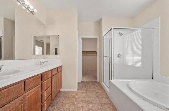 bathroom with tile patterned floors, vanity, and shower with separate bathtub