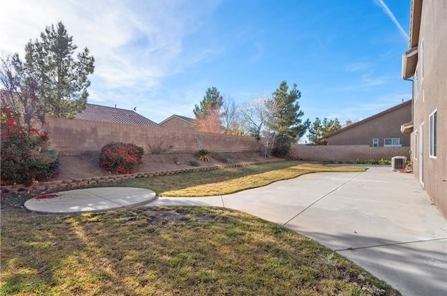 view of yard with central AC and a patio