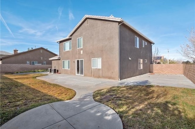 rear view of property featuring a lawn and a patio area