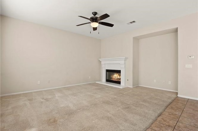 unfurnished living room featuring ceiling fan and light carpet