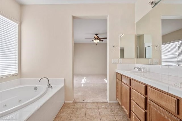 bathroom featuring vanity, a relaxing tiled tub, tile patterned floors, and ceiling fan