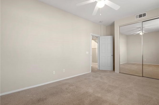 unfurnished bedroom featuring a closet, ceiling fan, and light colored carpet