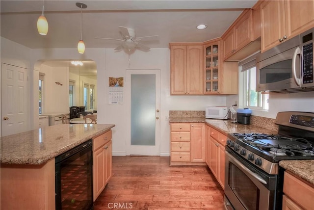 kitchen featuring hanging light fixtures, beverage cooler, stainless steel appliances, light brown cabinetry, and light wood-type flooring